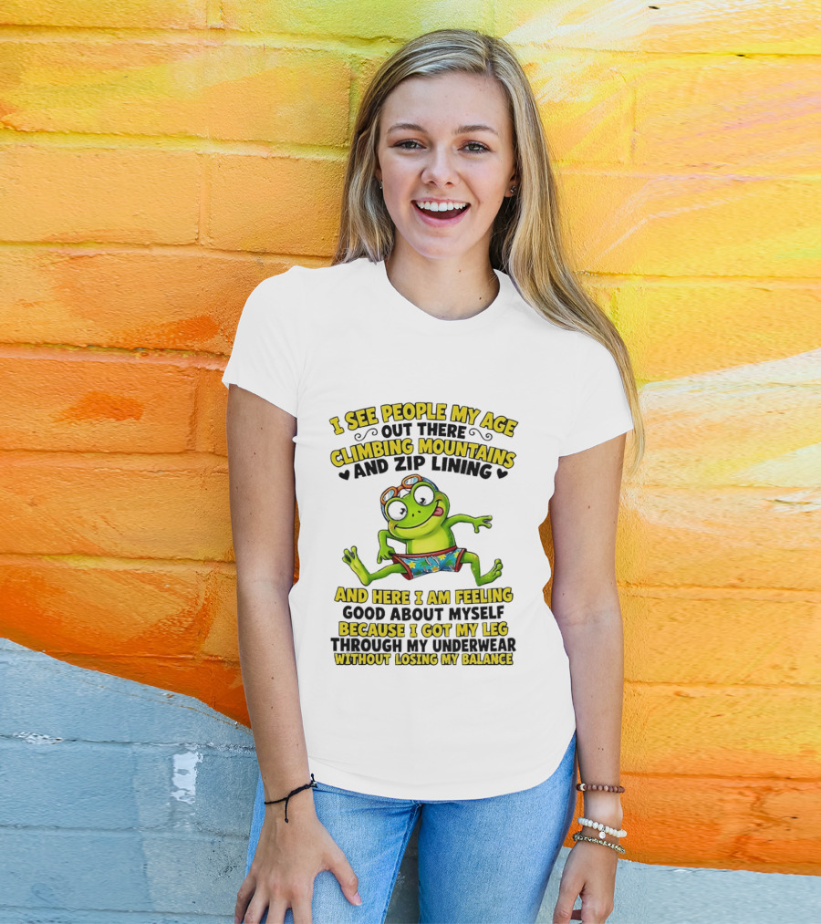 I See People My Age Climbing Mountains And Zip Lining Cartoon Frog Feeling Good Without Losing Balance T-Shirt
