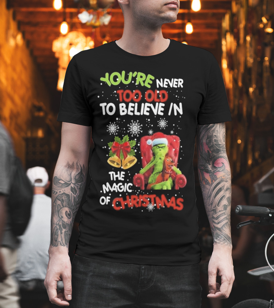 You're Never Too Old To Believe IN The Magic Of Christmas Grinch With Max Sitting IN Chair Snowflakes Holiday Bells And Bow T-Shirt